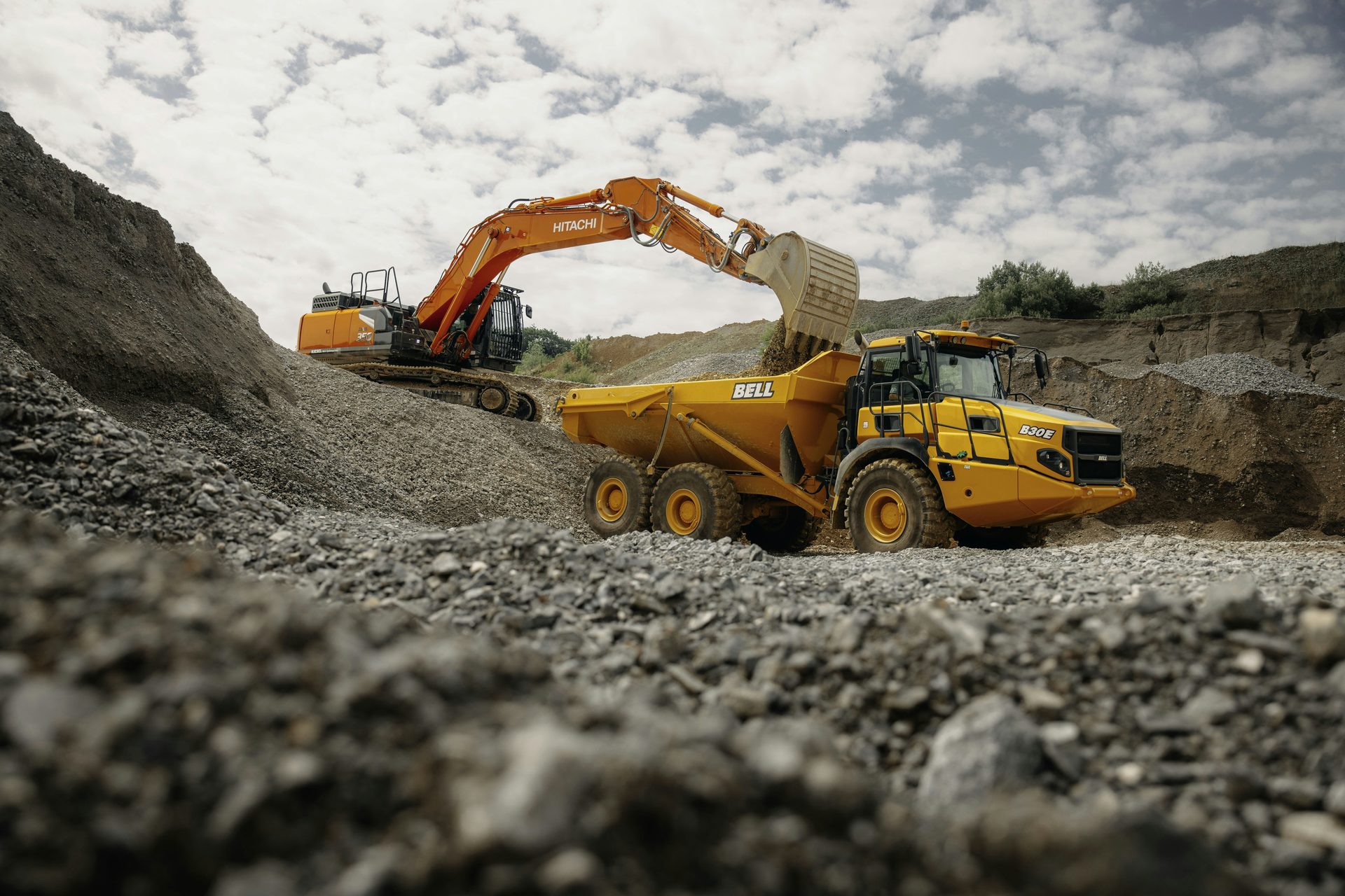 Excavator and dump truck in mining quarry