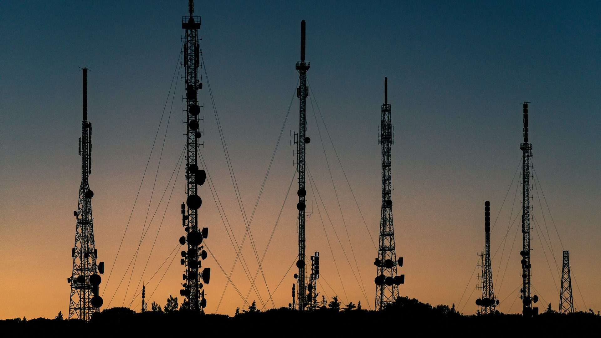 Telecommunication towers silhouetted at sunset